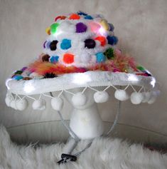 White cowboy hat White big pom pom tassels Clear fairy lights Multi-colored pom poms Multi-colored feather boa White yarn Cowboy Hat White, Cowboy Festival, Big Pom Pom, White Cowboy Hat, Coloured Feathers, Festival Hat, Costume Hats, Cowboy Hat, Pom Poms