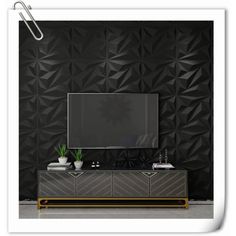 an entertainment center with a television on top of it in front of a black wall