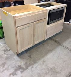 an unfinished kitchen cabinet with the doors open