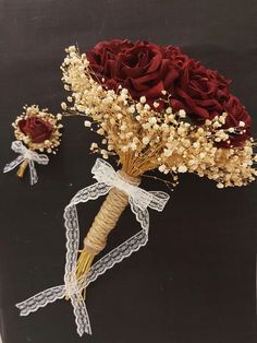 two bouquets of flowers on a black background with white lace and ribbon tied around the stems