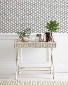 a white table topped with plants next to a wall