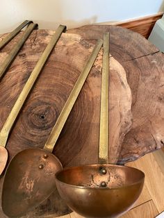 a wooden table topped with metal bowls and spoons