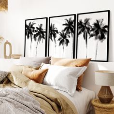 three black and white palm trees are on the wall above a bed with beige linens