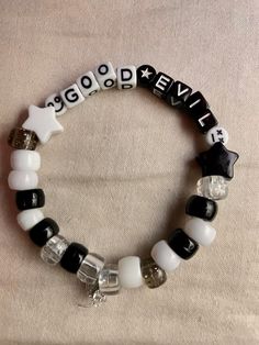 a black and white beaded bracelet that says good news on the front with stars