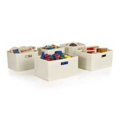 three white storage bins filled with toys