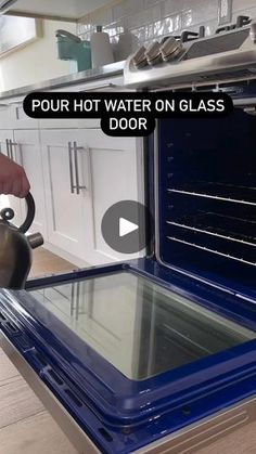 a person is holding a tea kettle over an oven door that has glass on it