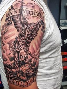 a man with a cross and angel tattoo on his arm that says saint michael protect us