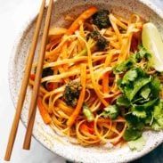 a bowl filled with noodles and vegetables next to chopsticks