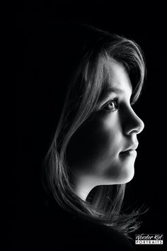 a black and white photo of a woman's face with long hair in profile