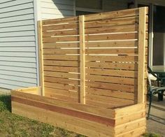 a wooden planter box sitting on the side of a house