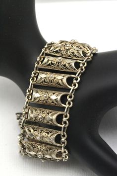 "Cannetille is a close relative of filigree work. It typically features fine gold wires or thinly hammered sheets. Jewelry with cannetille was very popular in the 1820's and 1830's. Motifs included tendrils, scrolls, coils, beehives and spider-like rosette ornaments. Jewelry featuring cannetille was often embellished with granulation and thinly stamped metals.  This gorgeous bracelet features 20 \"bars\" of cannetille, linked with tiny bars, and would look wonderful with any outfit!  This bracel Filigree Gold Jewellery, Rosette Ornaments, Filigree Jewellery, Gold Filigree Bracelet, Middle Eastern Jewelry, Ornaments Jewelry, Filigree Bracelet, Filigree Jewelry, Sterling Bracelets