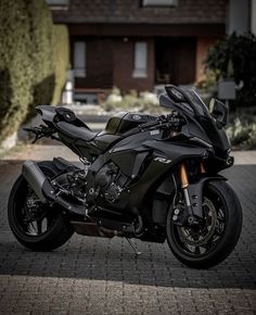 a black motorcycle parked in front of a house