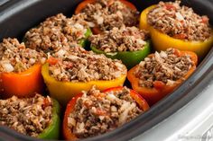 stuffed bell peppers with ground meat and vegetables in a slow cooker pot, ready to be cooked