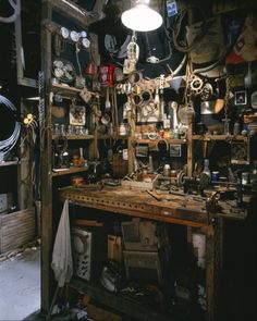 a room filled with lots of assorted items on top of a wooden table in front of a light