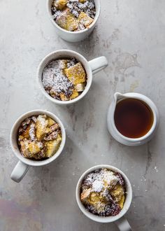 three mugs filled with food sitting on top of a table