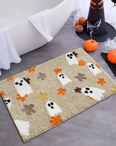 a halloween rug with ghostes and pumpkins on the floor next to a table