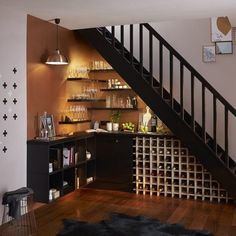 a wine rack under the stairs in a living room next to a stair case filled with bottles and glasses