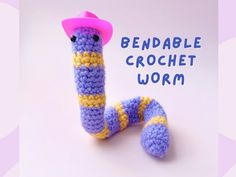 a crocheted worm with a pink hat on it's head and legs