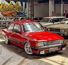 a red car parked in a garage next to other cars