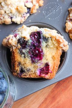 muffins with blueberries and crumbs in a muffin pan