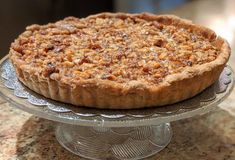 a pie sitting on top of a glass cake plate