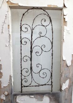 an old door with iron work on the front and side panels that have been painted white