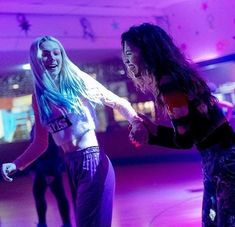 two young women are dancing on the dance floor