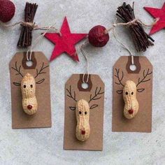 three christmas tags with reindeer noses and antlers hanging from strings on brown paper next to red stars