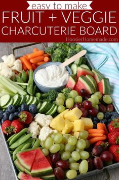 a tray filled with fruit and veggies on top of a wooden table