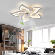 a white bed sitting under a ceiling light next to a dresser and window in a room