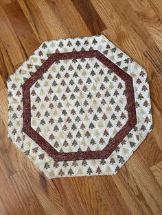 a white and red placemat sitting on top of a wooden floor