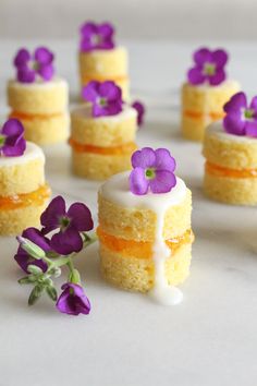 small cakes with purple flowers on top of them