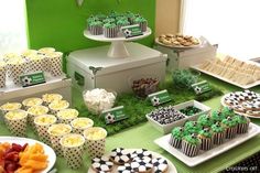 a green table topped with lots of cakes and cupcakes