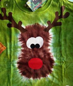 a green t - shirt with reindeer's nose and antlers painted on it