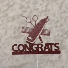 a cake topper with scissors and combs on it that says congrats