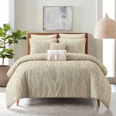 the comforter is beige and has white flowers on it, along with two pillows