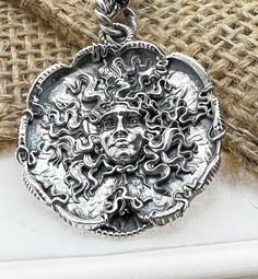 "Hand made Design by Sal Knight The Medusa in sterling silver light antique finish with ruby eyes 30 millimeters wide, 1 1/4\" inches Double linked sterling silver chain" Luxury Oxidized Finish Jewelry For Collectors, Luxury Collectible Jewelry With Oxidized Finish, Silver Hand Forged Medallion Jewelry, Luxury Oxidized Silver Jewelry, Luxury Silver Jewelry With Oxidized Finish, Sterling Silver Pendant With Antique Finish, Antique Finish Sterling Silver Pendant, Spiritual Jewelry With Antique Finish, Antique Silver Sterling Silver Jewelry