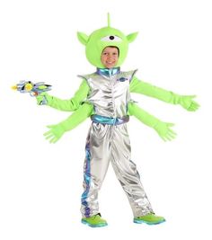 a young boy in a costume that is green and silver with hands out to the side