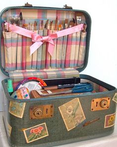 an open suitcase sitting on top of a white shelf next to a wall with various items in it