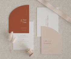 the wedding stationery is laid out on top of each other, with a ribbon tied around it