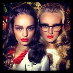 two beautiful young women wearing glasses and red lipstick