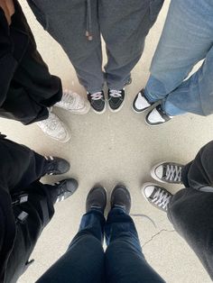 four people standing in a circle with their feet on each other's hipss