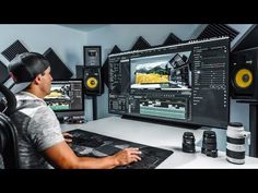 a man sitting at a desk in front of a computer monitor with sound mixing equipment on it