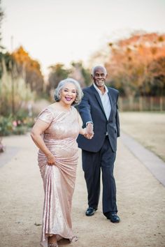 an older man and woman holding hands in front of a photo on the phone screen