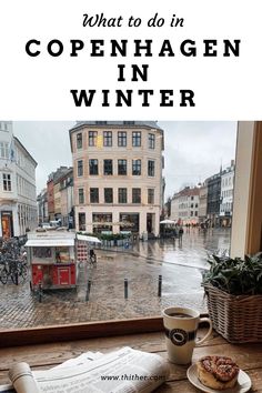 a cup of coffee sitting on top of a table next to a window