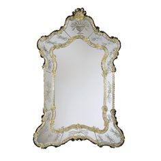 an ornate mirror with gold trimmings and beading on the edges, against a white background