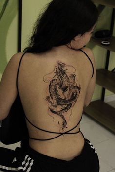 a woman with a dragon tattoo on her back