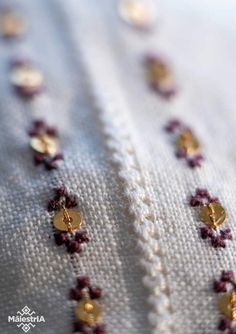 closeup of gold and red beads on white fabric