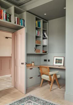 a room with a desk, chair and bookshelf in it's corner