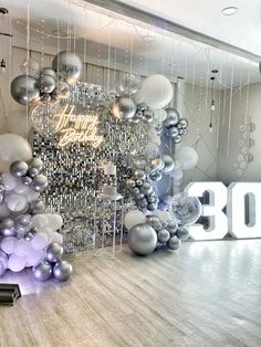 balloons and streamers are hanging from the ceiling in front of a sign that says happy 30th